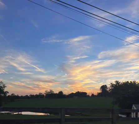 Sunset over open farmland and a split-rail fence in Worcester